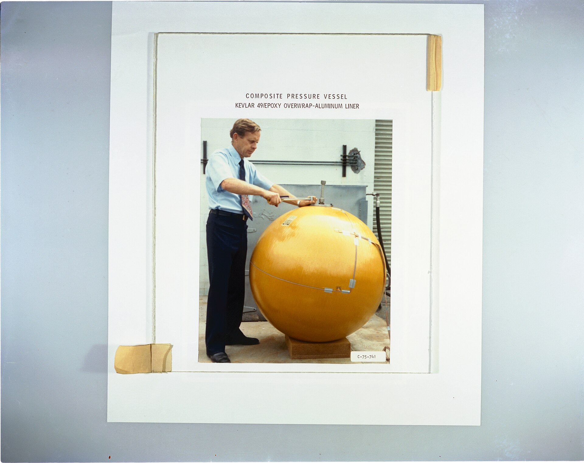 A pressure vessel fractured in a high pressure burst test, beside an intact composite vessel