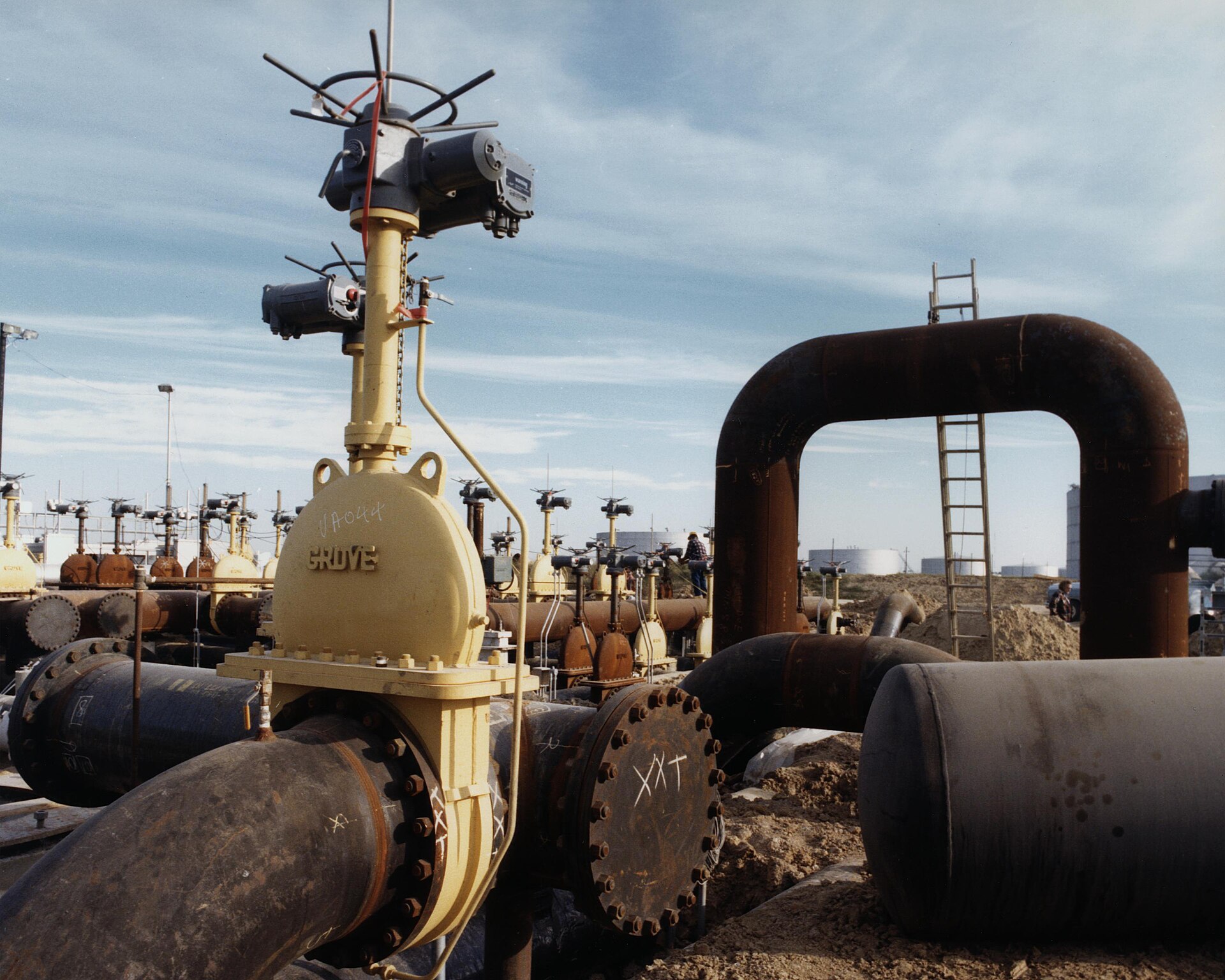 Rows of large storage tanks and connecting pipework at a strategic petroleum reserve site