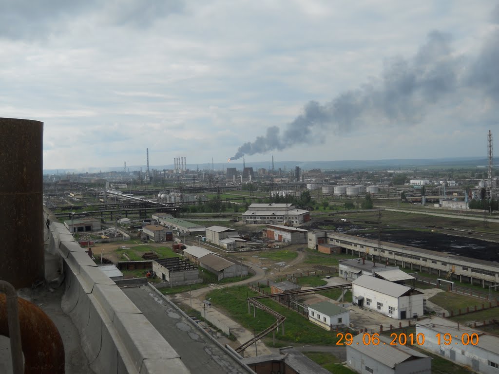 Petrochemical plant with columns, tanks and pipe racks seen across open ground