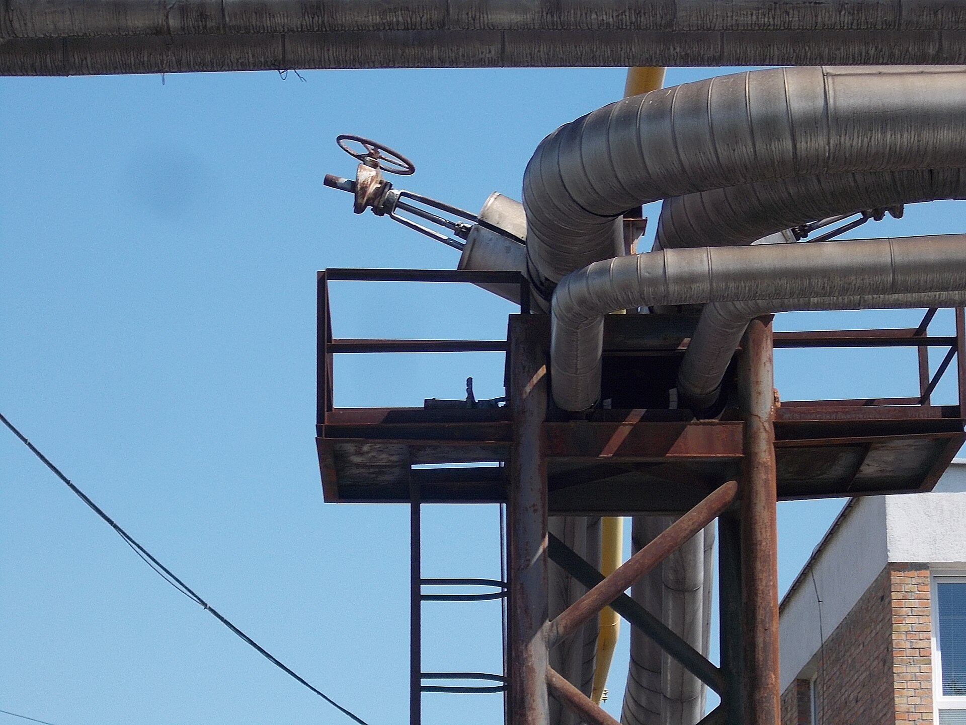 A manual valve on a rack-mounted pipeline at a former factory site