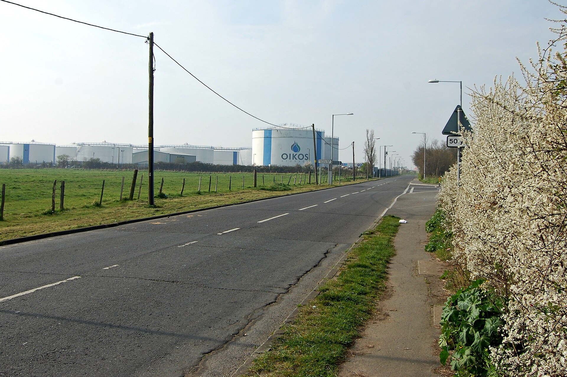 A row of large oil storage tanks standing in an industrial yard