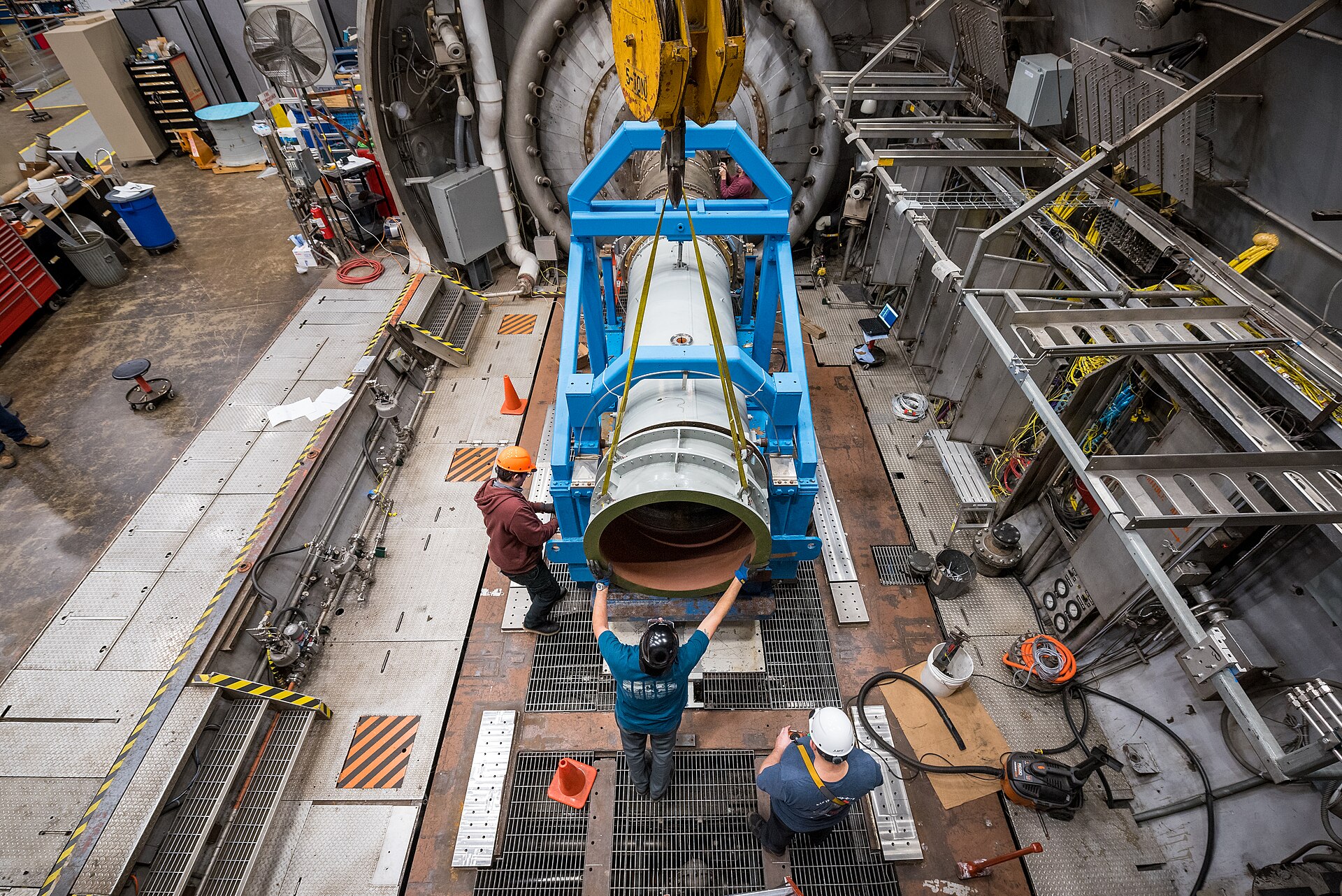 An engineering team documenting a nozzle test in a propulsion laboratory, an example of hardware tested for reliability